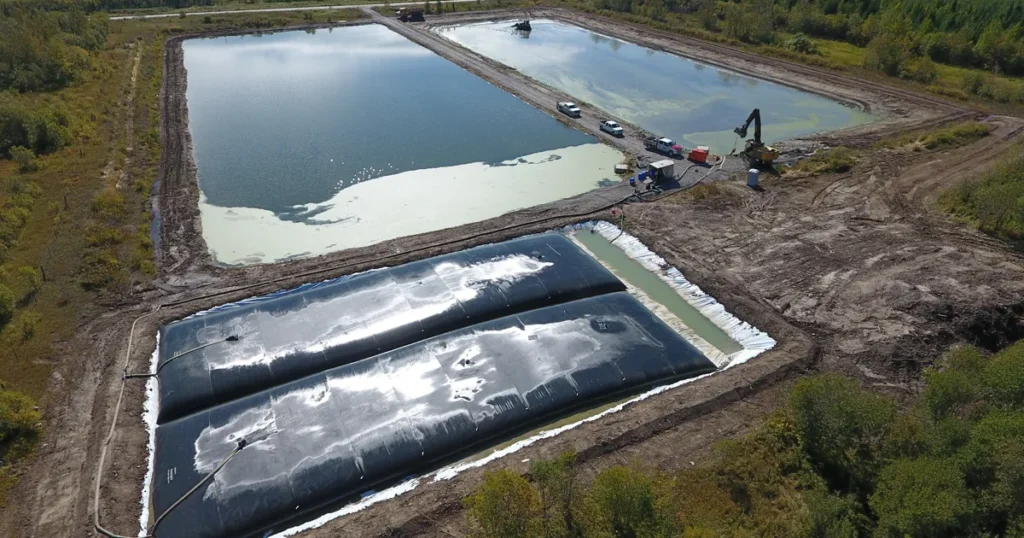 Geotube containers collecting and dewatering sludge from wastewater lagoons.