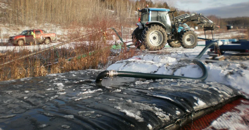Arsenic sludge being pumped into a Geotube dewatering unit in winter